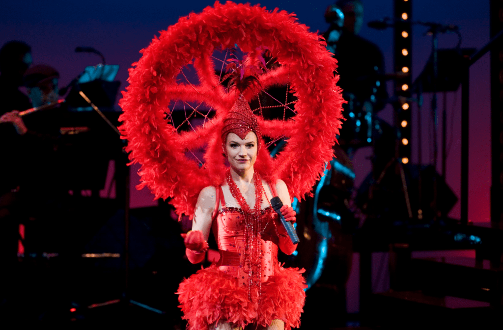 Cecilia Frode står i en spektakulär röd klänning på scen.