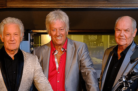Medlemmarna i The Mule Skinner Band ler mot kameran inklädda kavaj.