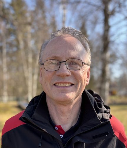 Lennart Hagman står leendes, utomhus, och ser in i kameran.