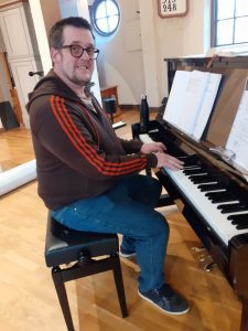 Messaging1683538239379 Fredrik Almqvist sitter vid ett piano och tittar in i kameran.