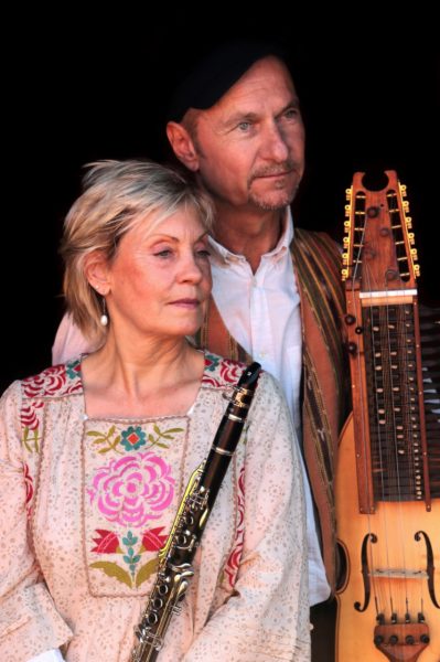 Ute och Alban Faust står med klarinett respektive nyckelharpa mot en svart bakgrund.